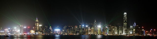 An image showcasing a bustling street in Hong Kong, with vibrant neon signs illuminating the dark sky